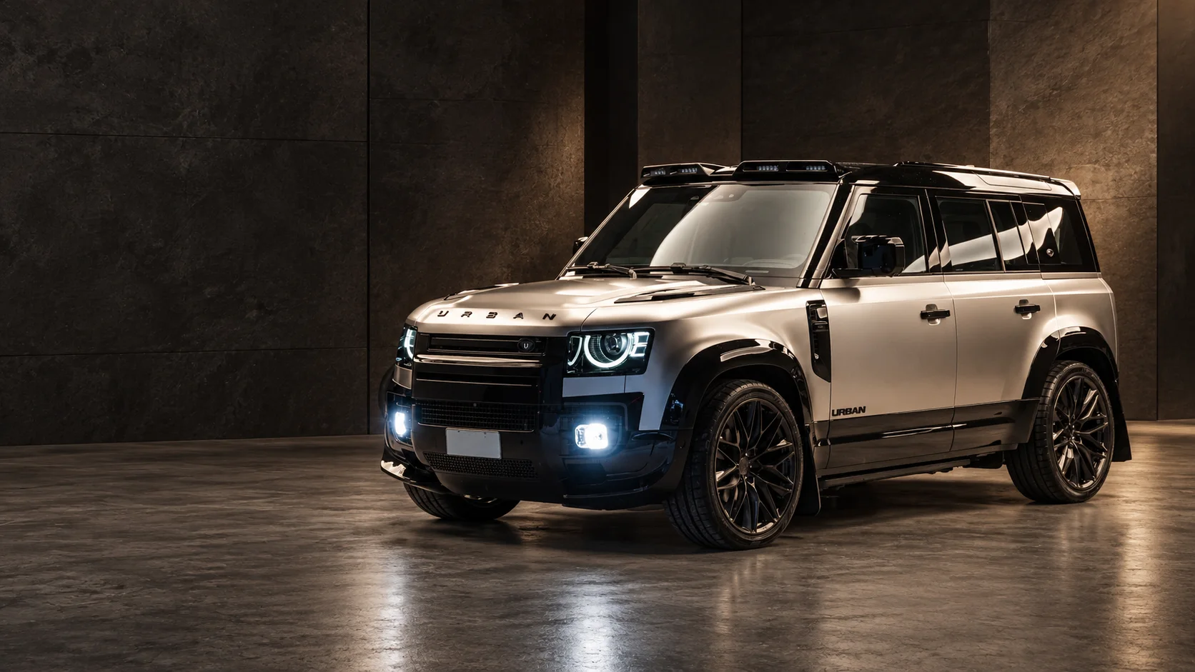 Land Rover Defender Urban da MODUZZ em estúdio escuro, faróis acesos